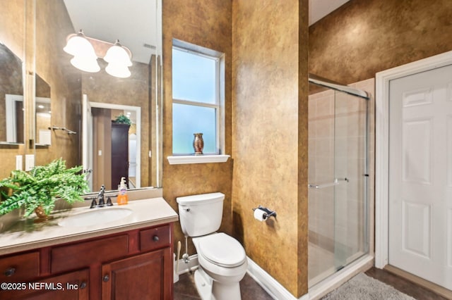 bathroom featuring vanity, toilet, and a shower with door