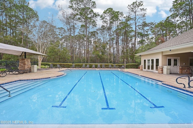 view of swimming pool with french doors and a patio area