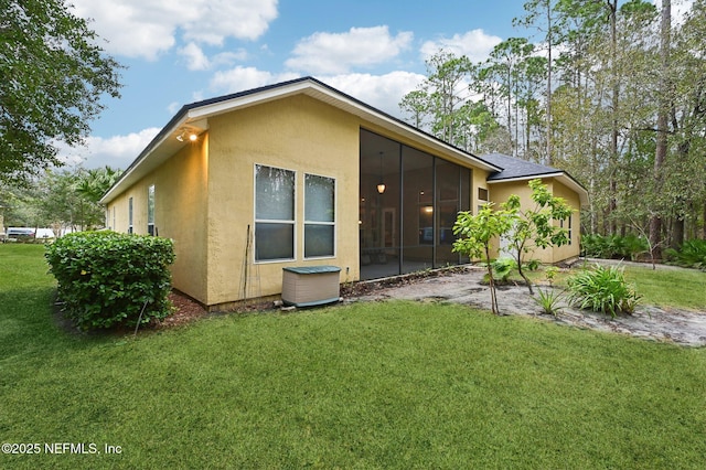 back of property featuring a lawn and a sunroom