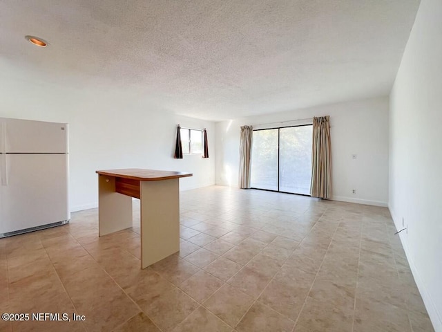 unfurnished room featuring light tile patterned floors and a textured ceiling