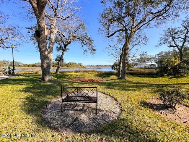 surrounding community with a lawn and a water view