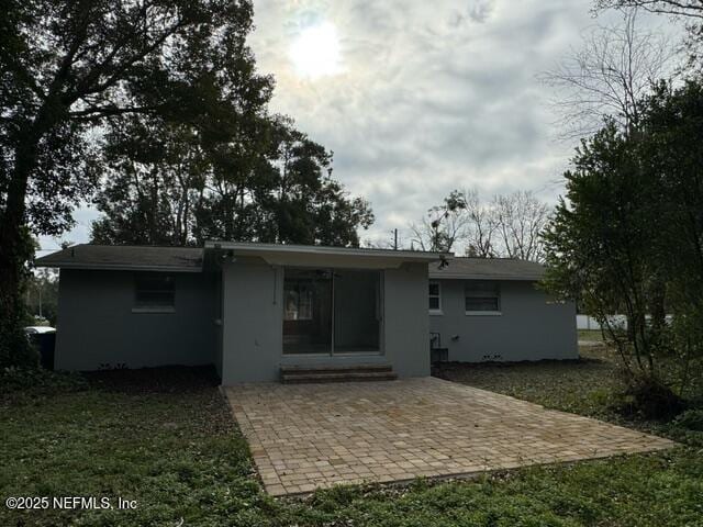 rear view of house featuring a lawn and a patio area