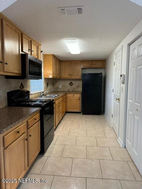 kitchen featuring backsplash, a textured ceiling, sink, black appliances, and light tile patterned floors