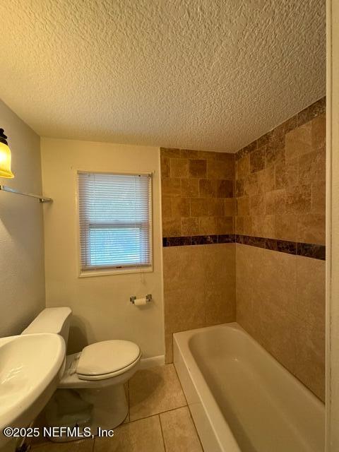 bathroom with sink, tile patterned flooring, a textured ceiling, and toilet