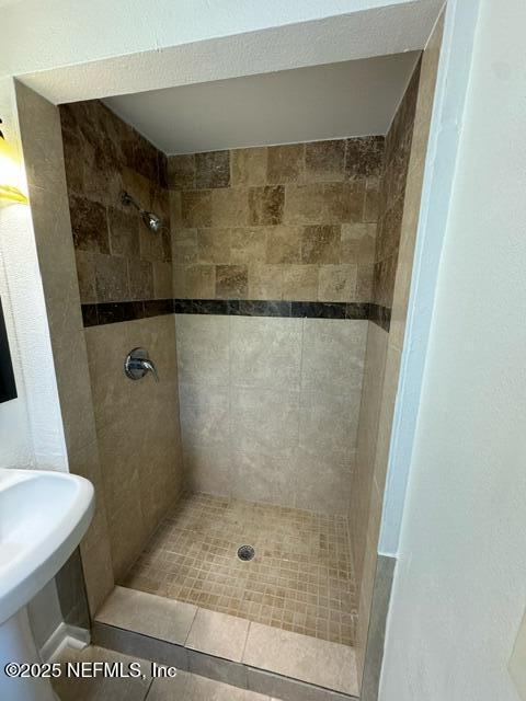 bathroom featuring a tile shower, tile patterned floors, and sink