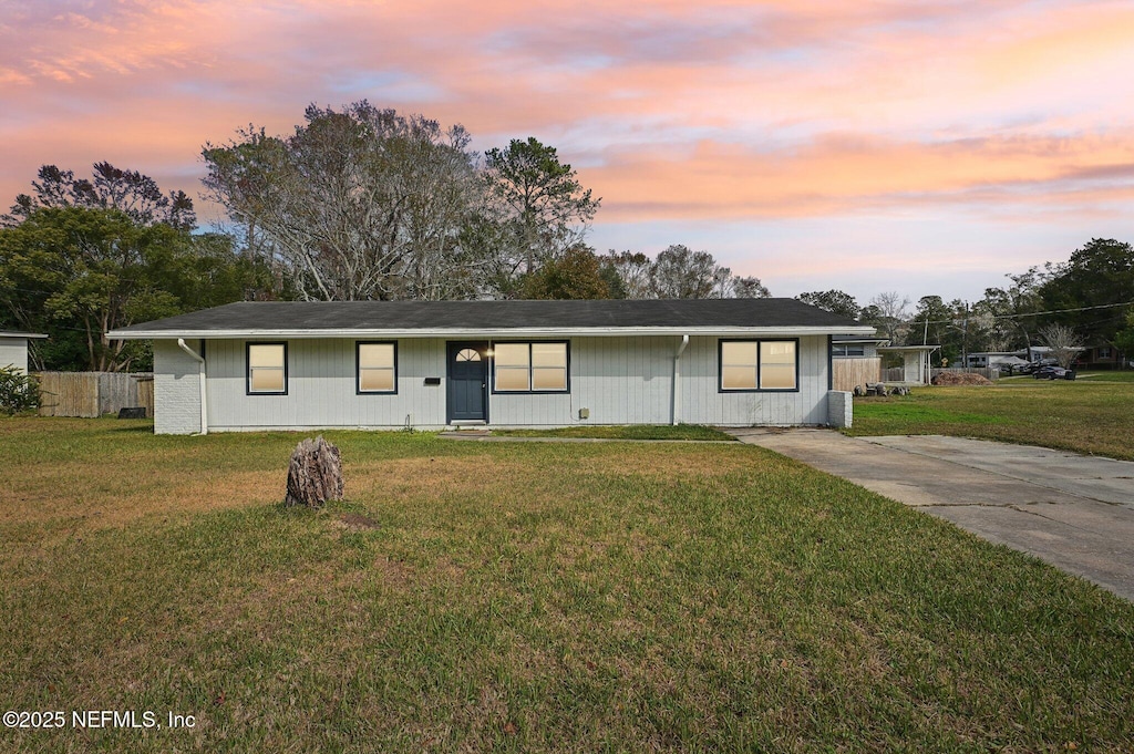 ranch-style home with a yard