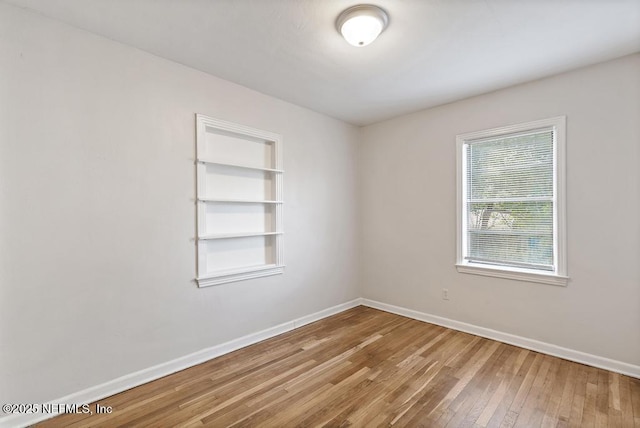 unfurnished room with wood-type flooring