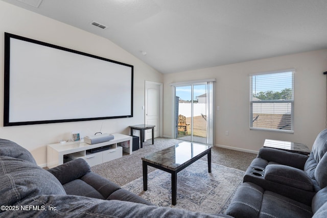 carpeted cinema room with vaulted ceiling and a wealth of natural light