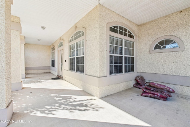 view of exterior entry featuring a patio