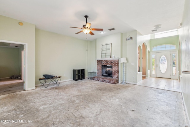 unfurnished living room with a brick fireplace and ceiling fan