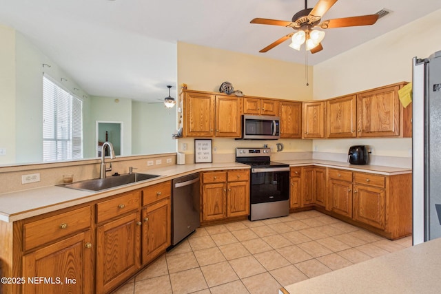 kitchen featuring sink, light tile patterned floors, appliances with stainless steel finishes, kitchen peninsula, and ceiling fan