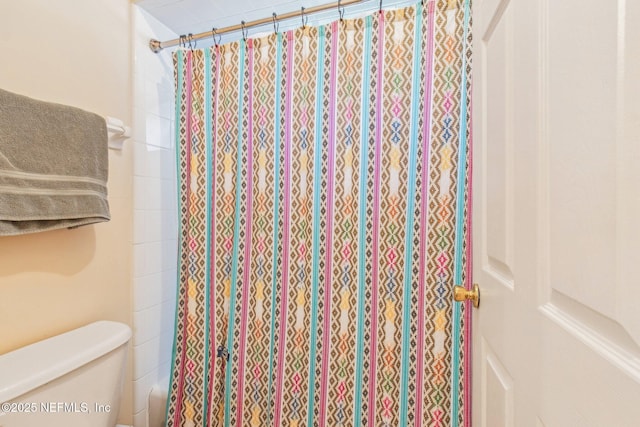 bathroom featuring toilet and walk in shower