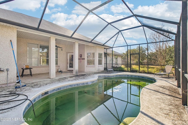 view of swimming pool with ceiling fan, a lanai, and a patio