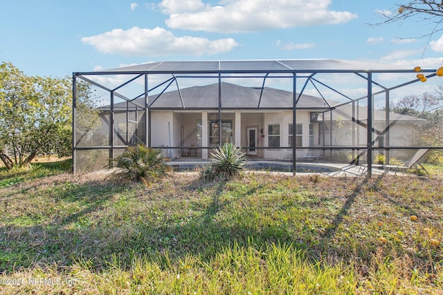 back of house with a lanai and a patio area