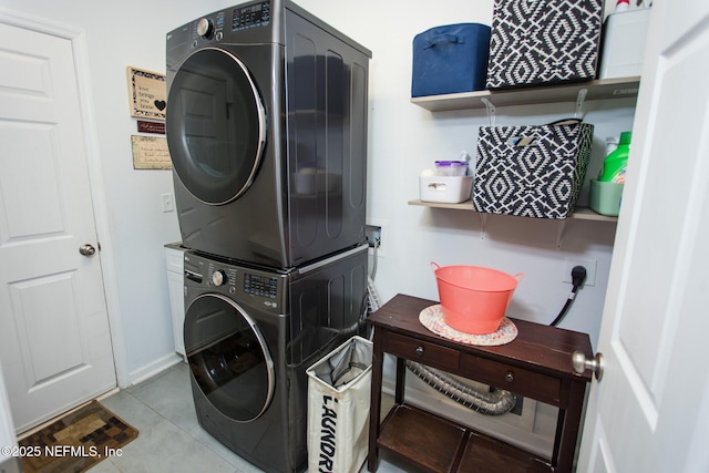 laundry room featuring light tile patterned floors and stacked washer and clothes dryer