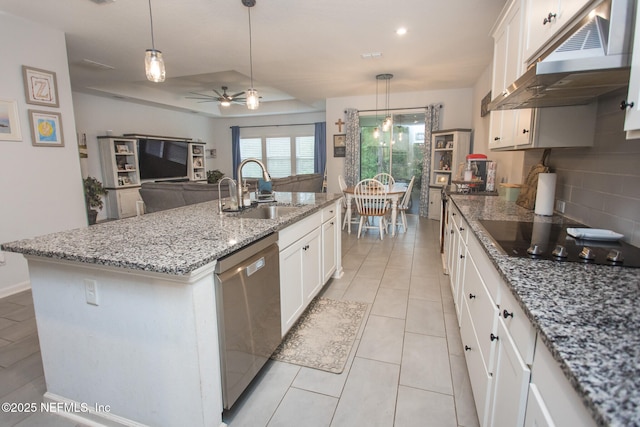 kitchen with stainless steel dishwasher, sink, white cabinetry, and an island with sink