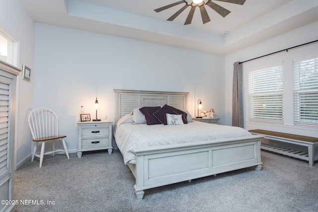 bedroom featuring carpet flooring, ceiling fan, and a tray ceiling