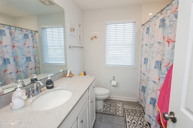 bathroom featuring tile patterned flooring, vanity, a healthy amount of sunlight, and toilet