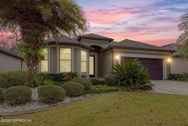 view of front facade with a yard and a garage