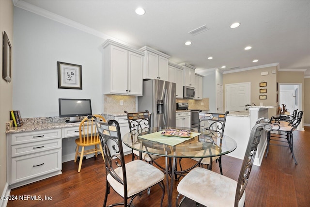 dining room featuring crown molding, built in desk, and dark wood-type flooring