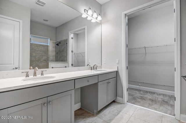 bathroom with vanity, tiled shower, and tile patterned floors