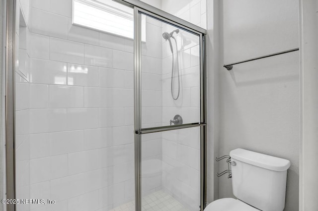 bathroom featuring an enclosed shower and toilet