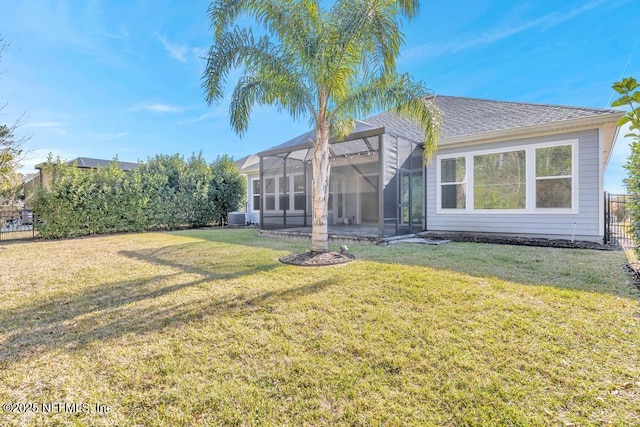 rear view of property with a lanai and a lawn