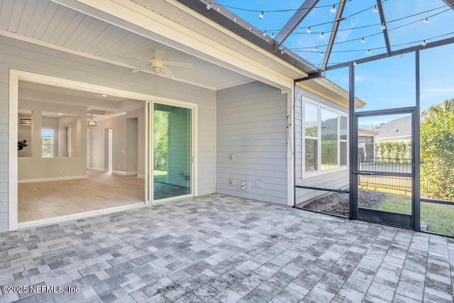 unfurnished sunroom with beam ceiling and ceiling fan