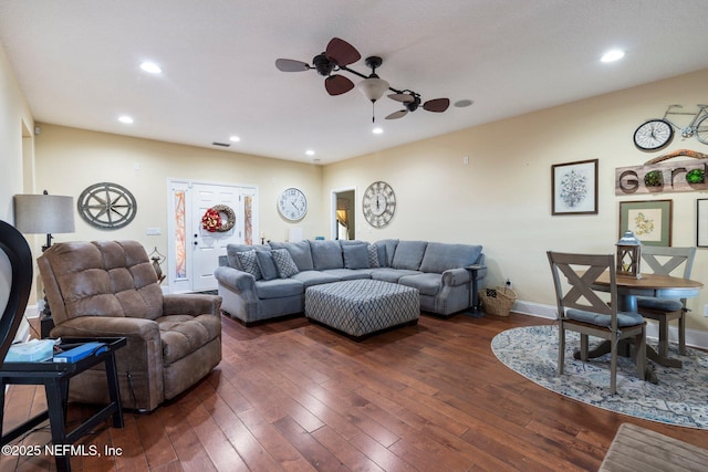 living room with ceiling fan and dark wood-type flooring