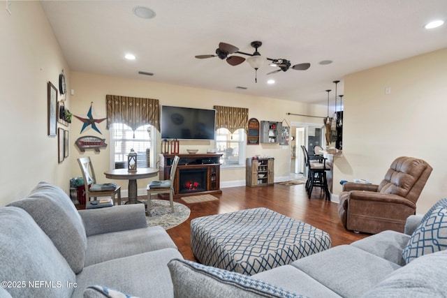 living room with ceiling fan and dark hardwood / wood-style flooring