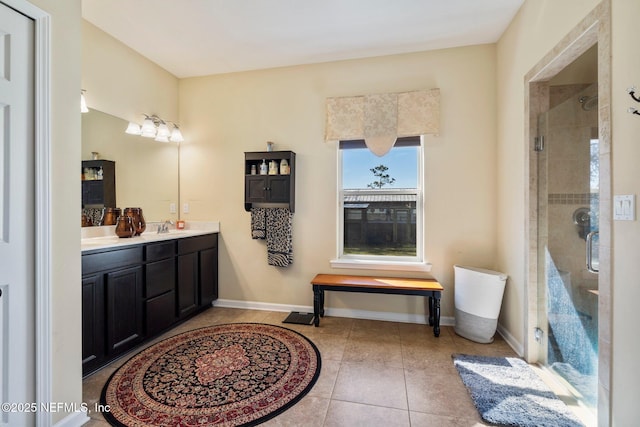 bathroom featuring a shower with door, vanity, and tile patterned flooring