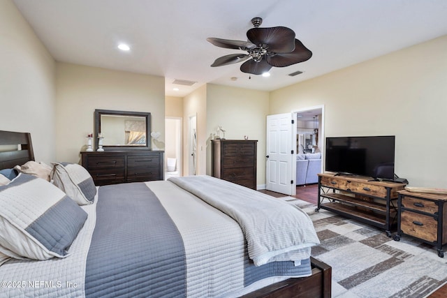 bedroom featuring ensuite bathroom, hardwood / wood-style floors, and ceiling fan