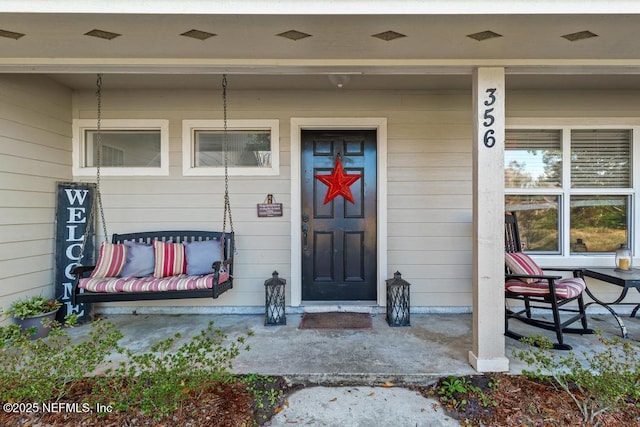 view of exterior entry with covered porch