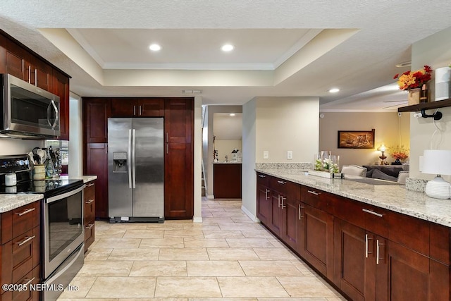 kitchen featuring crown molding, appliances with stainless steel finishes, and a raised ceiling