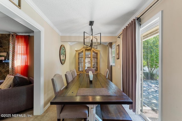 carpeted dining room with a notable chandelier, ornamental molding, and a textured ceiling