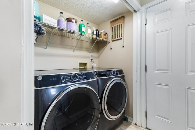 laundry room with separate washer and dryer and a textured ceiling