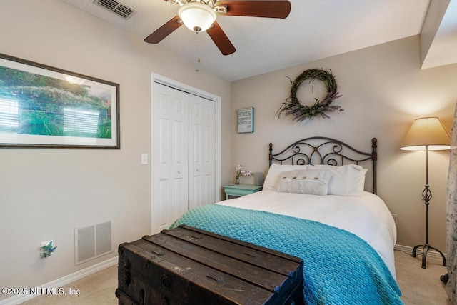 bedroom featuring light carpet, ceiling fan, and a closet