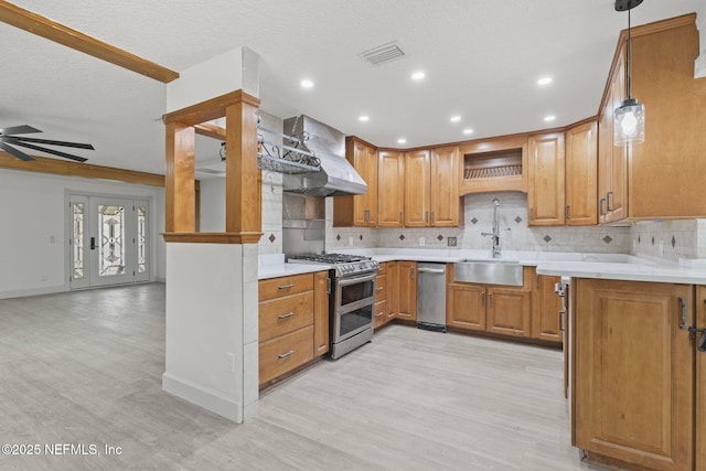 kitchen with stainless steel gas stove, sink, hanging light fixtures, tasteful backsplash, and extractor fan