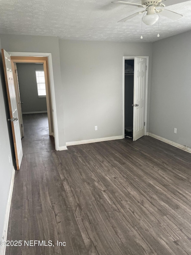 unfurnished room featuring ceiling fan, dark hardwood / wood-style flooring, and a textured ceiling