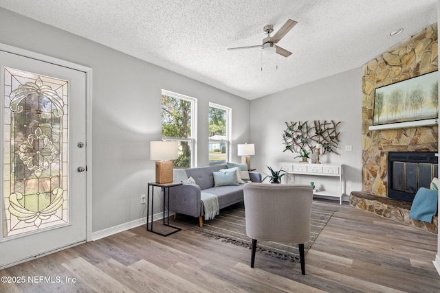 living room featuring hardwood / wood-style floors, a fireplace, and a textured ceiling