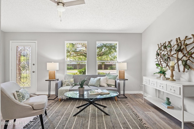 living room featuring ceiling fan, a healthy amount of sunlight, a textured ceiling, and hardwood / wood-style flooring