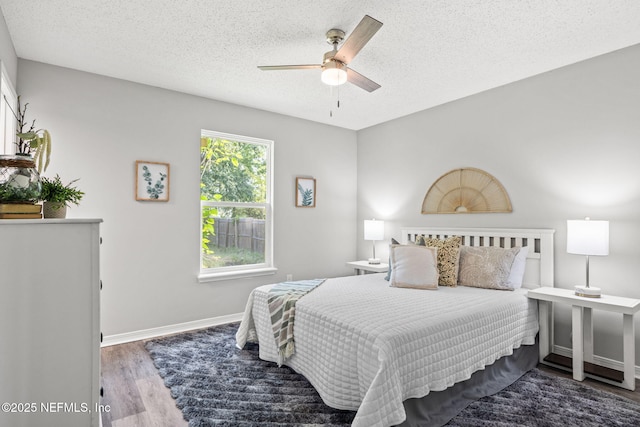 bedroom with wood-type flooring, a textured ceiling, and ceiling fan