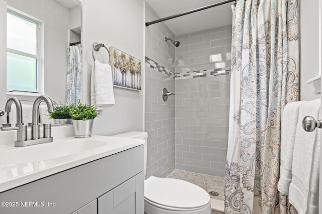 bathroom featuring a shower with shower curtain, vanity, and toilet