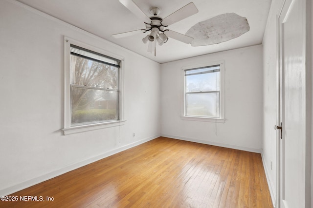 unfurnished room with plenty of natural light, ceiling fan, and light wood-type flooring