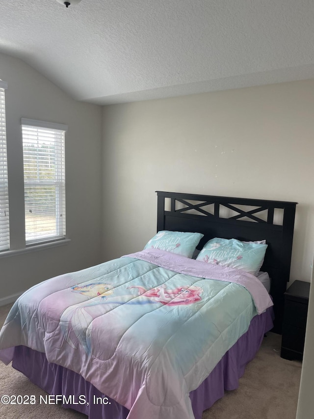 bedroom with carpet floors, a textured ceiling, and lofted ceiling