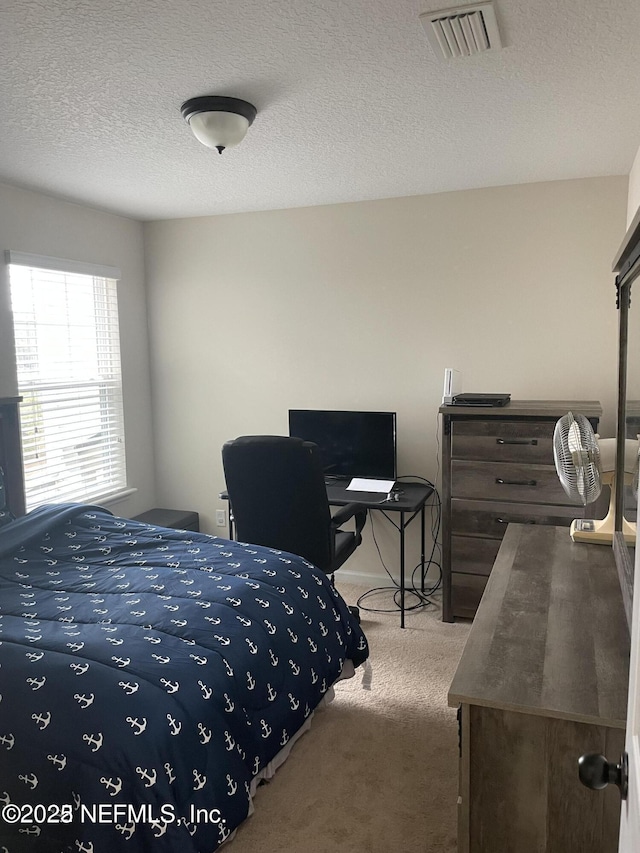 bedroom with carpet and a textured ceiling