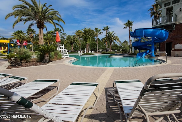 view of pool featuring a water slide and a patio