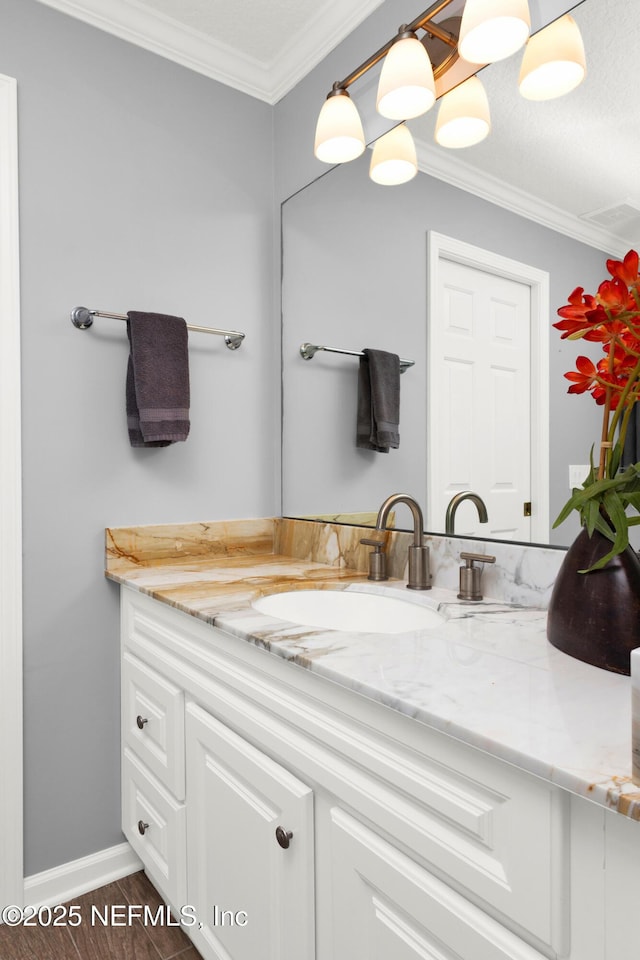 bathroom with hardwood / wood-style floors, crown molding, and vanity