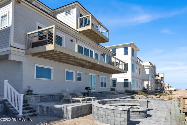 exterior space with an outdoor fire pit and a patio