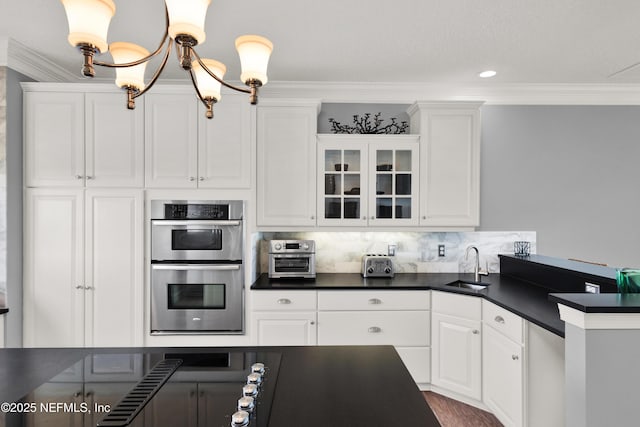 kitchen with double oven, crown molding, and white cabinetry